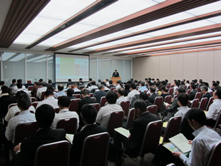 企業とNGOを招いたシンポジウムで挨拶する佐藤会長（2015年5月）