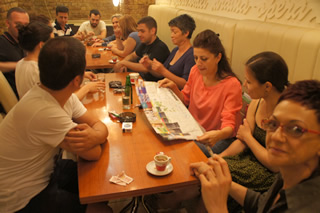 日本のホールでは珍しいステージ裏の出演者専門カフェでくつろぐバルカン楽団メンバー。喫煙率は高め。どのテーブルに座るか?も興味深い。(© 後調正則氏)
