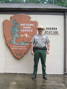 国立公園局のマーク「アローヘッド」と法執行担当のレンジャー（マンモスケイブ国立公園）